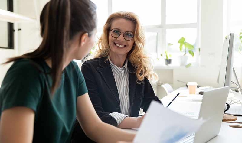 Two ladies sitting a desk